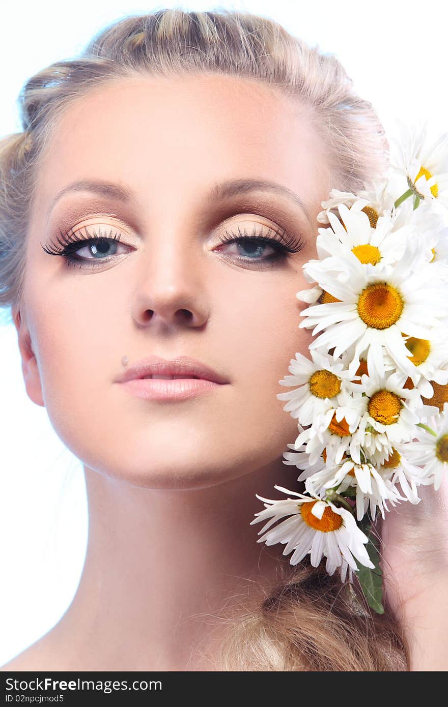 Close-up portrait of a fresh and beautiful woman with camomile.