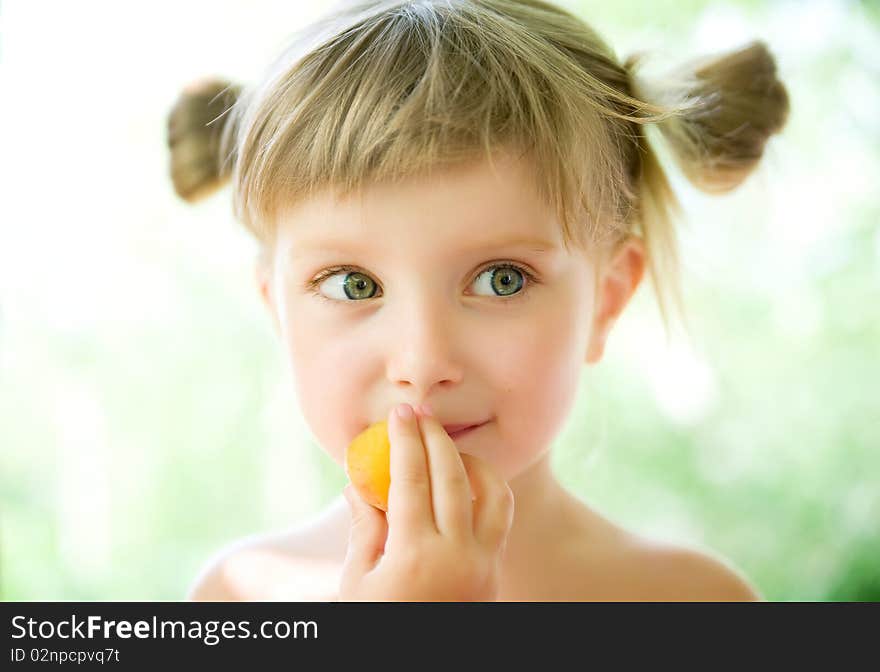 Close-up portrait of a cute liitle girl with the apricot. Close-up portrait of a cute liitle girl with the apricot