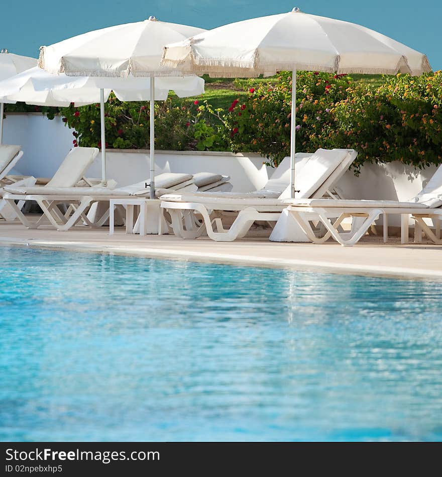 Plank beds with umbrellas at pool