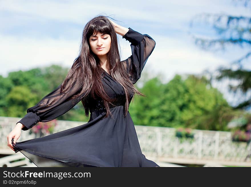 Young beautiful girl with long black hair, outdoors