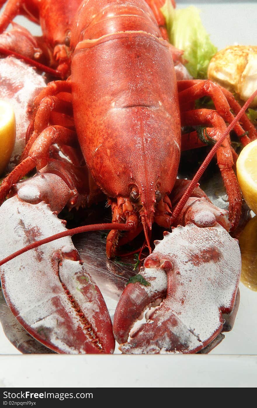 Steamed red boiled lobster with salad leaves and lemon in  restaurant . Steamed red boiled lobster with salad leaves and lemon in  restaurant .