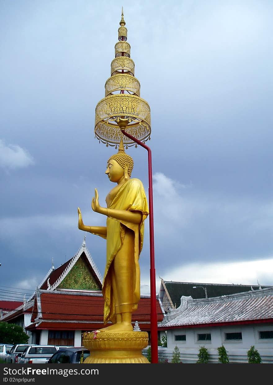 Beautiful stand buddha in front of temple.Stand buddha in golden tone color
with Thai art umbrella. Beautiful stand buddha in front of temple.Stand buddha in golden tone color
with Thai art umbrella.