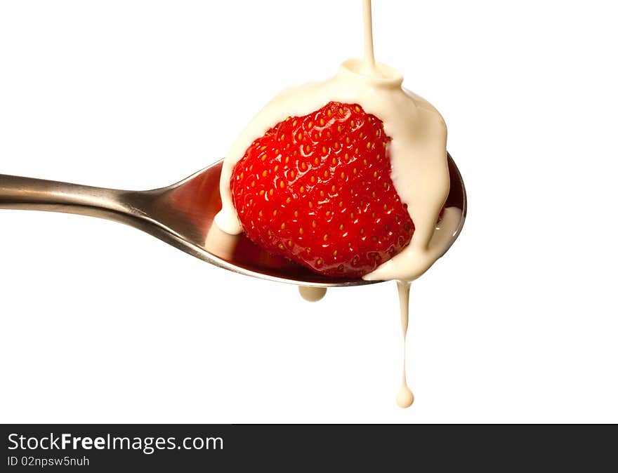 Fresh cream dripping on a strawberry sat in a spoon. Fresh cream dripping on a strawberry sat in a spoon