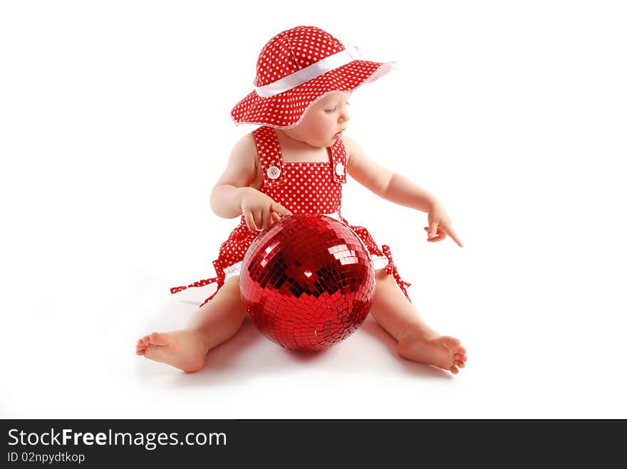 Little baby girl in red dress and hat with red ball