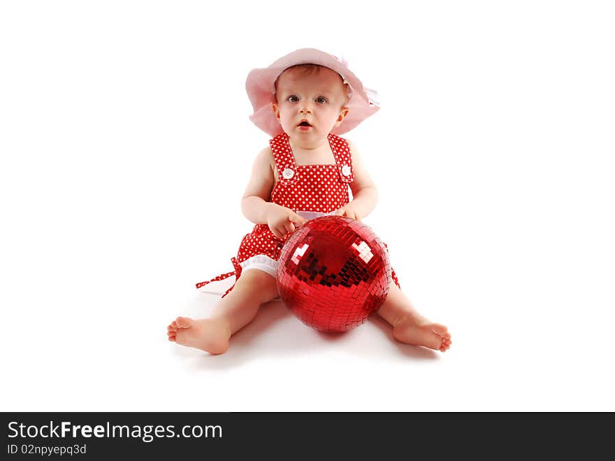 Little baby girl in red dress and hat with red ball