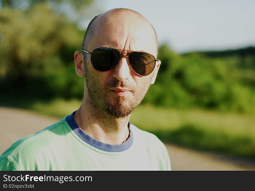 Man with sunglasses in middle of nature