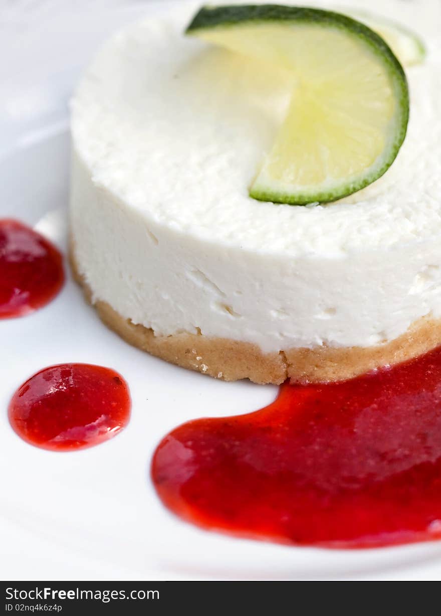 Fresh cheesecake served with lemon and strawberry sauce