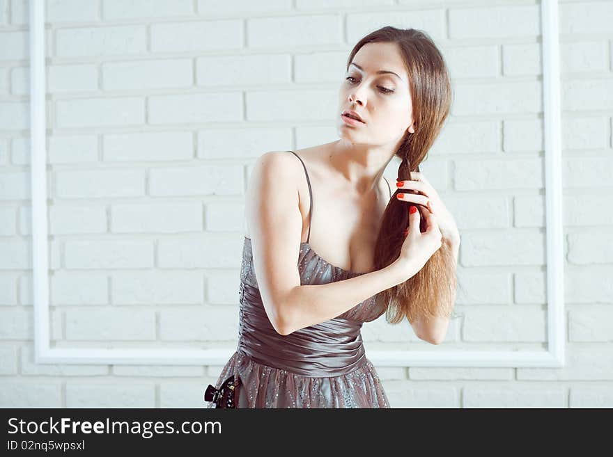 Romantic young lady combing in beautiful dress