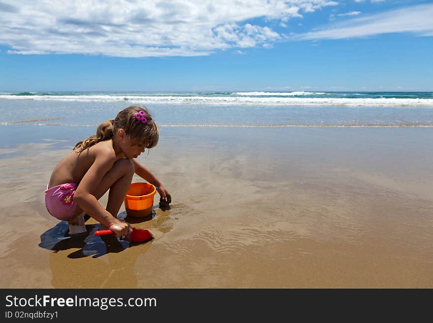 A girl playing on the wet sand