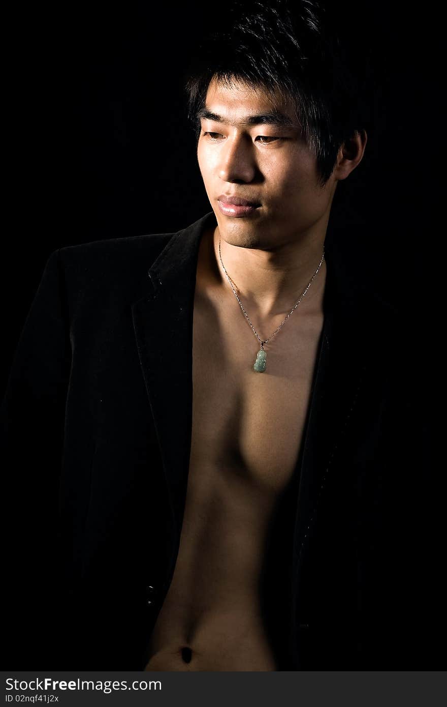 A handsome man on black background,exposing his fit breast. A handsome man on black background,exposing his fit breast