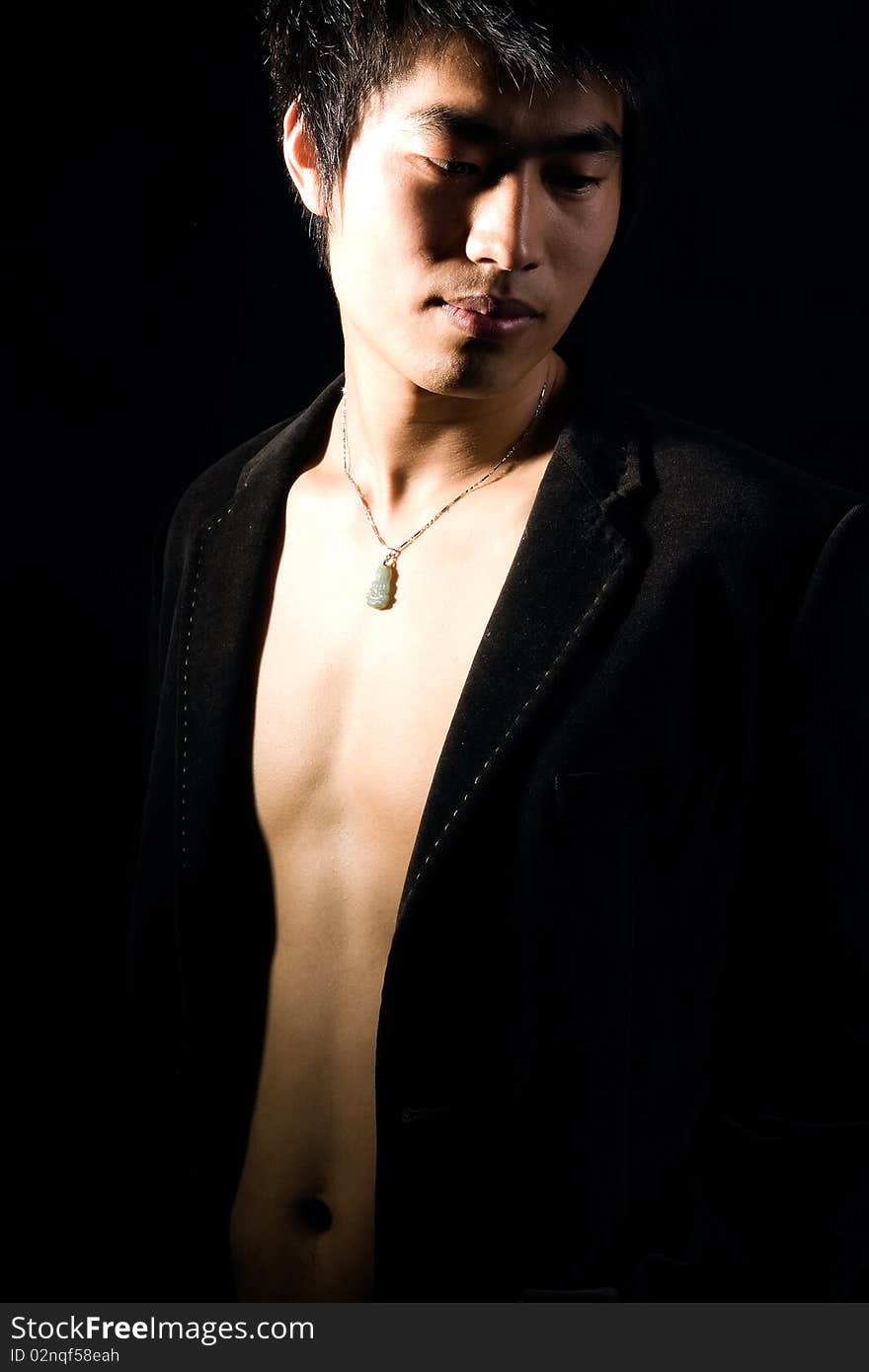 A handsome man on black background,exposing his fit breast. A handsome man on black background,exposing his fit breast