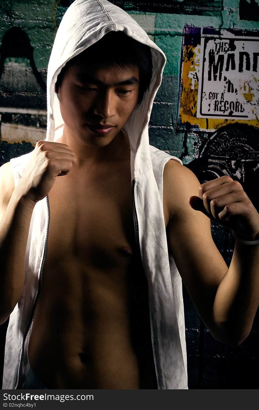 A male boxer in white jersey,clenching his fists. A male boxer in white jersey,clenching his fists