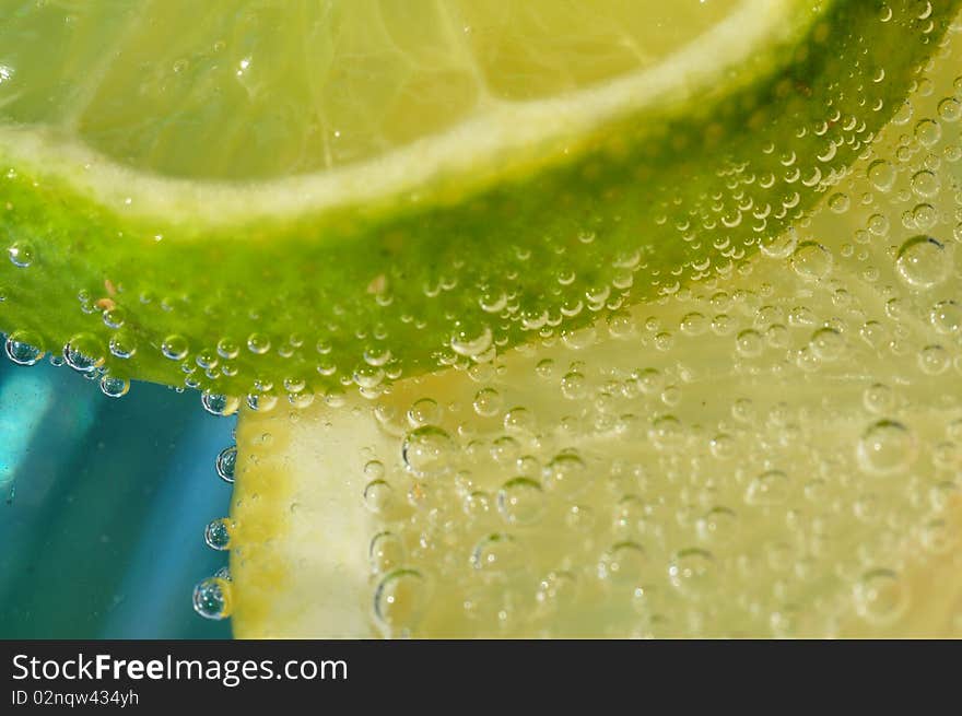 Close up/macro image of a lemon and lime slice in carbonated water. Close up/macro image of a lemon and lime slice in carbonated water.