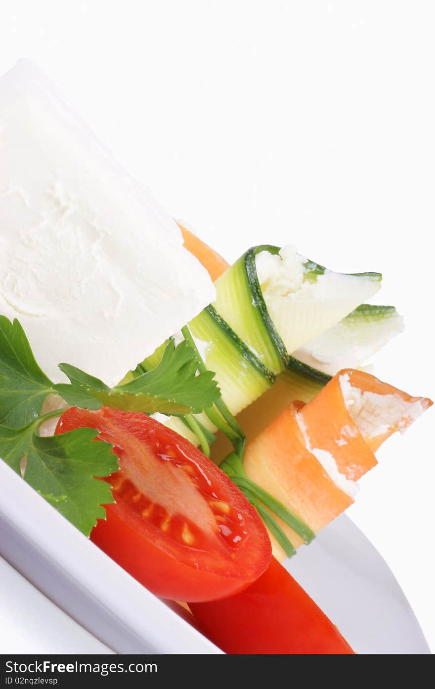 Cream cheese, Piccadilly tomatoes, zucchini and carrot rolls with cream cheese finely disposed on a white plate. Cream cheese, Piccadilly tomatoes, zucchini and carrot rolls with cream cheese finely disposed on a white plate.