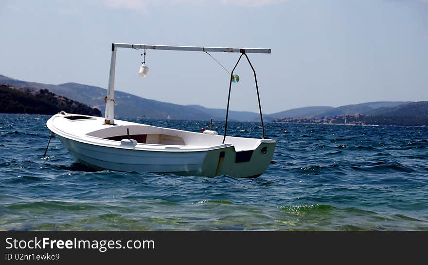 The spirit of holidays - small white boat on the sea waves