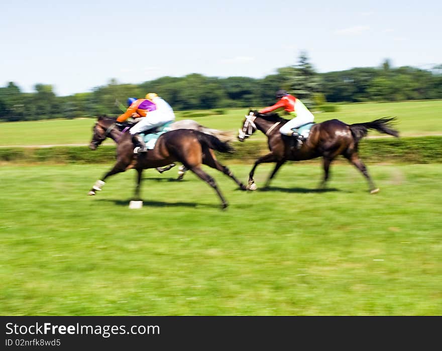 Horse racing on green racecourse, motion blurred. Horse racing on green racecourse, motion blurred