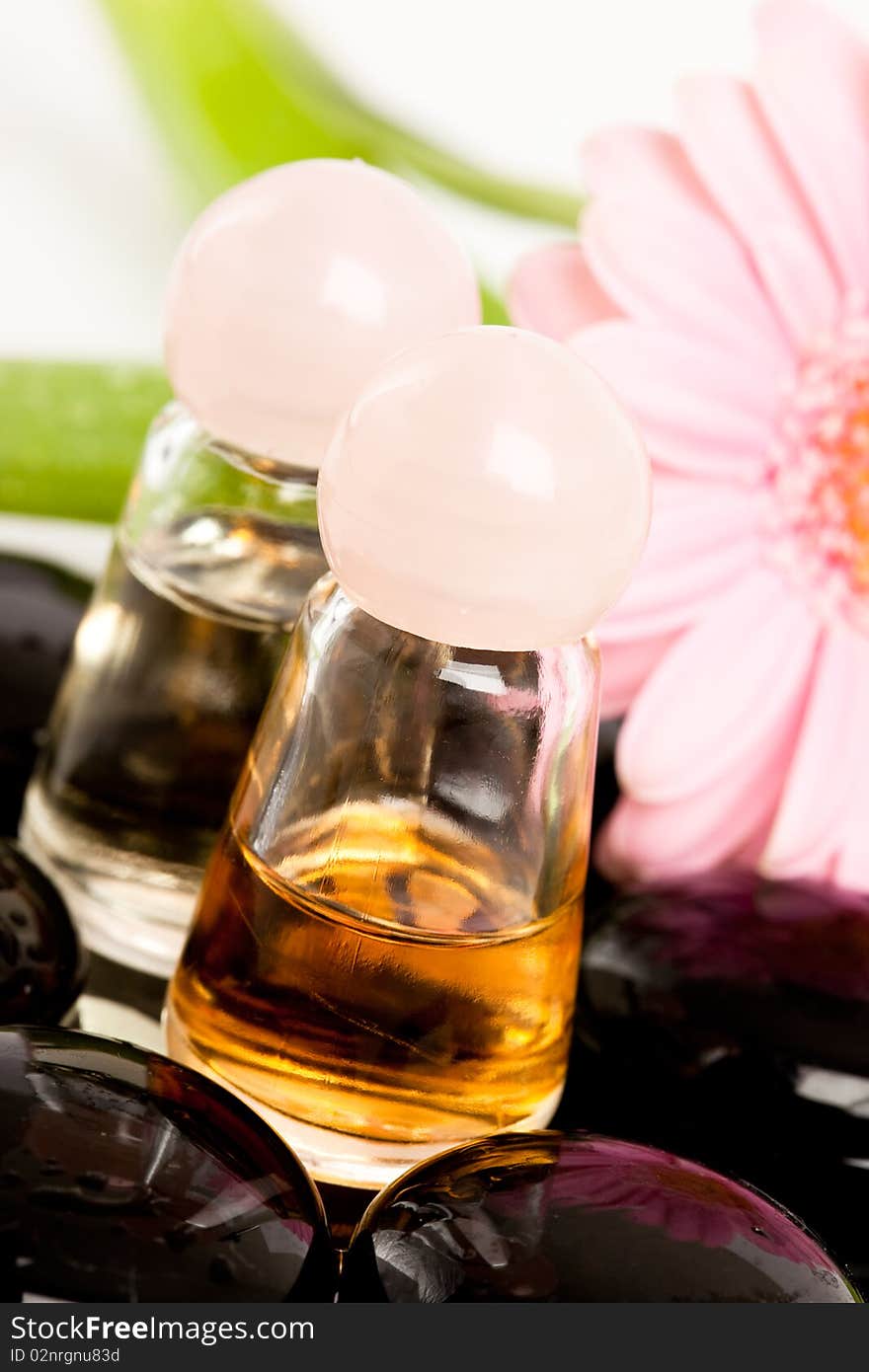 Spa essentials (stones with flower and bottles of oil)