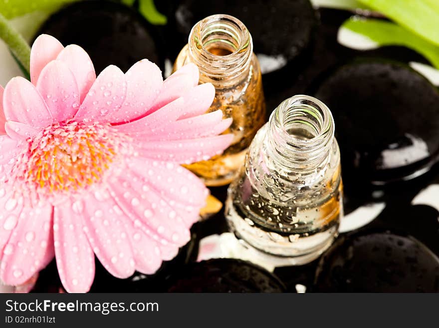 Spa essentials (stones with flower and bottles of oil)