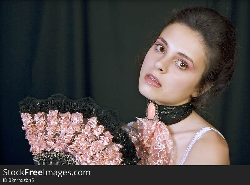 Portrait of a beautiful young girl with a fan