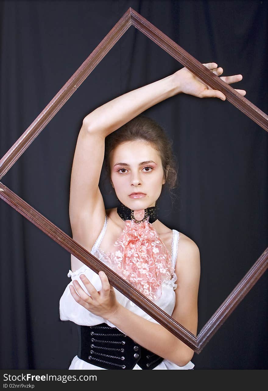 Beautiful young girl with a wooden frame in the hands of. Beautiful young girl with a wooden frame in the hands of