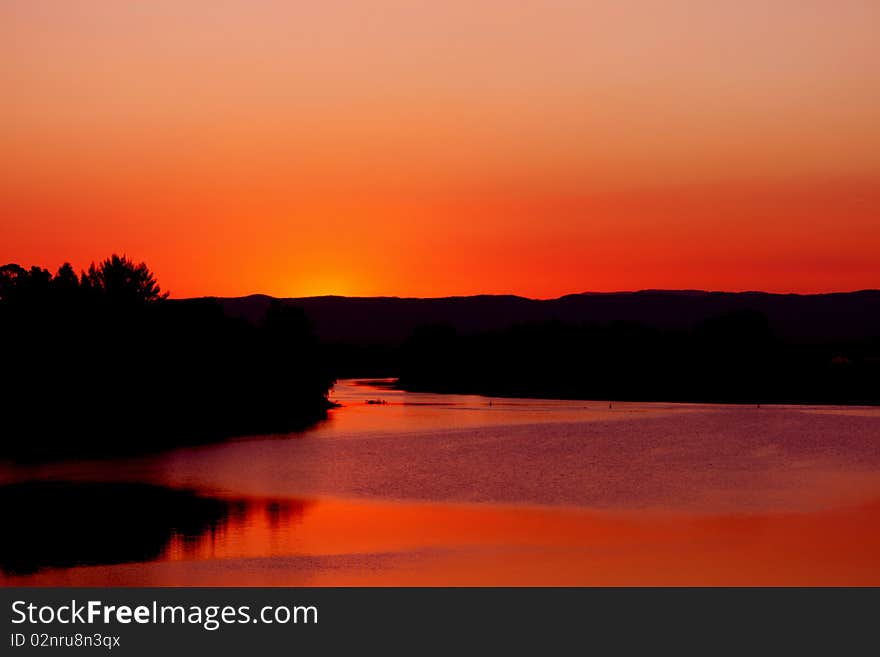 The sun puts on an explosive display to end the daylight. Bright red and orange lights up the sky and changes the colour of its environment. The sun puts on an explosive display to end the daylight. Bright red and orange lights up the sky and changes the colour of its environment.