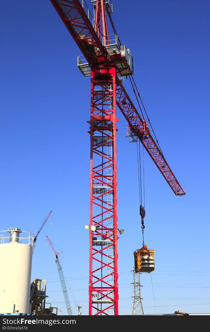 A heavy duty crane moving objects around an industrial workplace. A heavy duty crane moving objects around an industrial workplace.