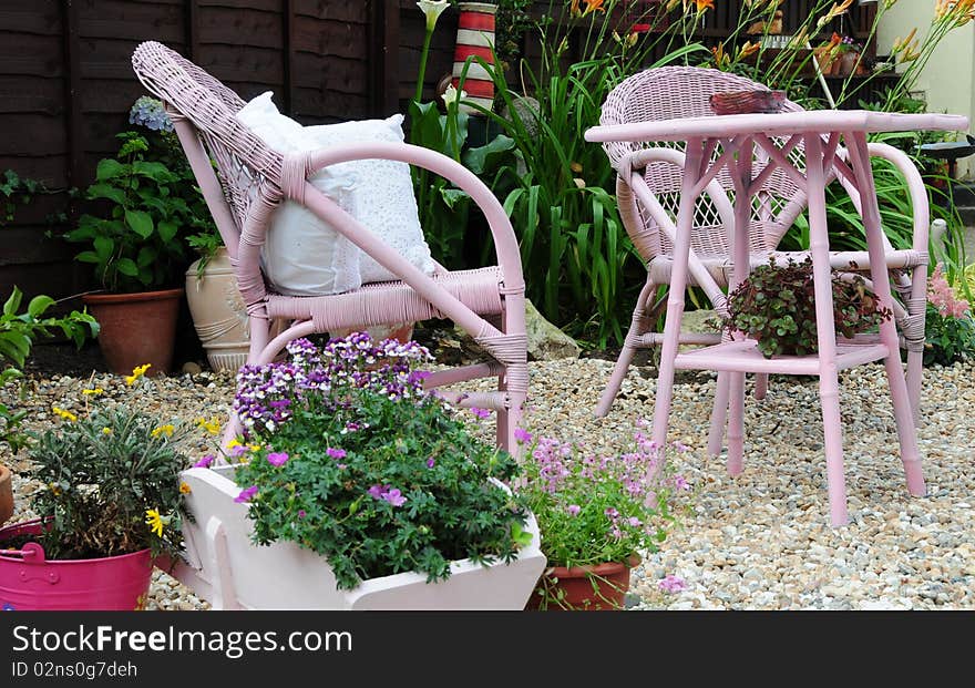 A shingled patio area with chairs for relaxing in the garden. A shingled patio area with chairs for relaxing in the garden