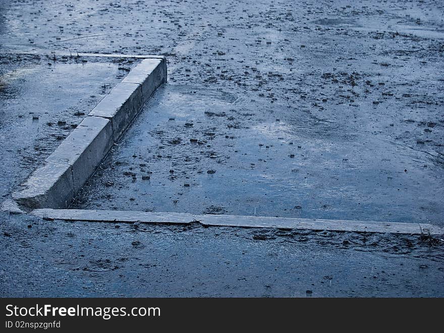 Drop in puddles on the road in a rainy day. Drop in puddles on the road in a rainy day