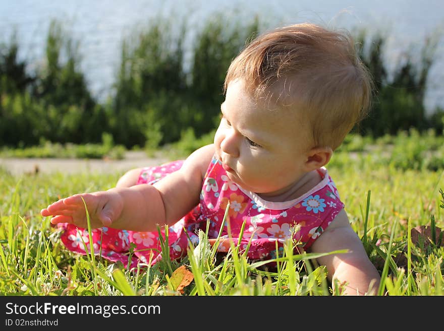 The girl lays on a grass near lake. The girl lays on a grass near lake