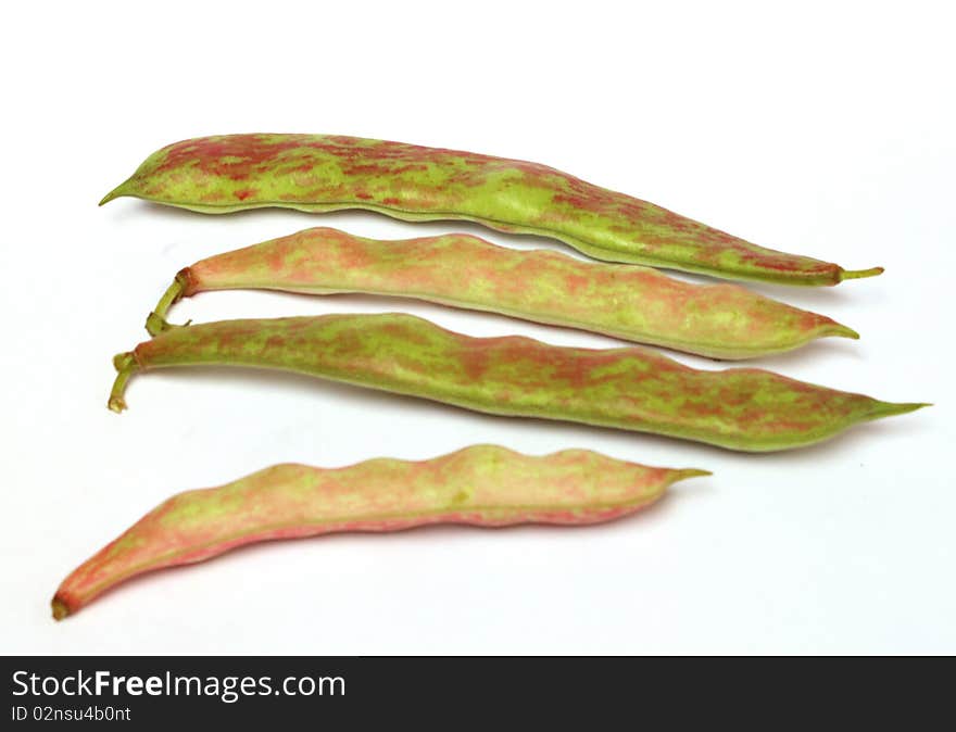 Four red-green pod color beans separately lie on a white background. Four red-green pod color beans separately lie on a white background