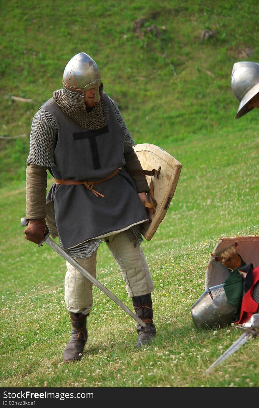 Medieval knight with metal helmet and sword preparing in the battlefield. Medieval knight with metal helmet and sword preparing in the battlefield.