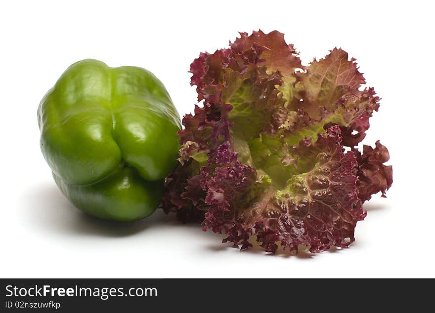 Green pepper and salad leaves on a white background. Green pepper and salad leaves on a white background.