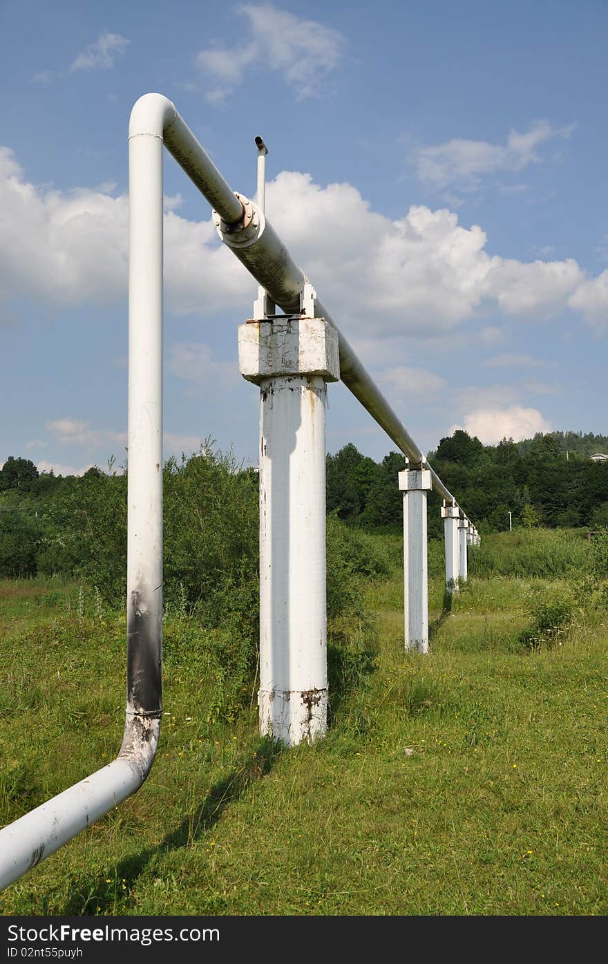 The pipeline of low pressure in a summer landscape under clouds. The pipeline of low pressure in a summer landscape under clouds.