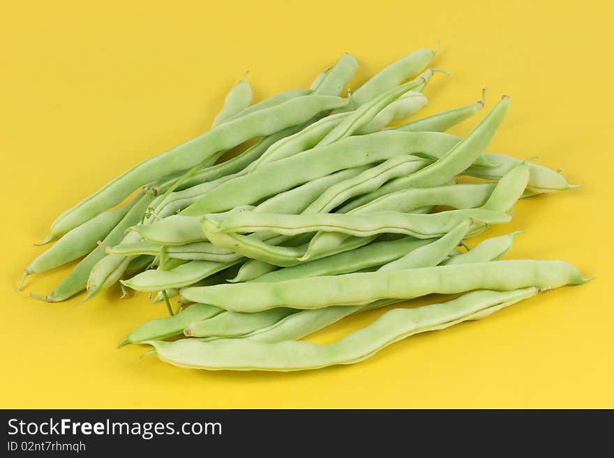 Green beans on yellow background