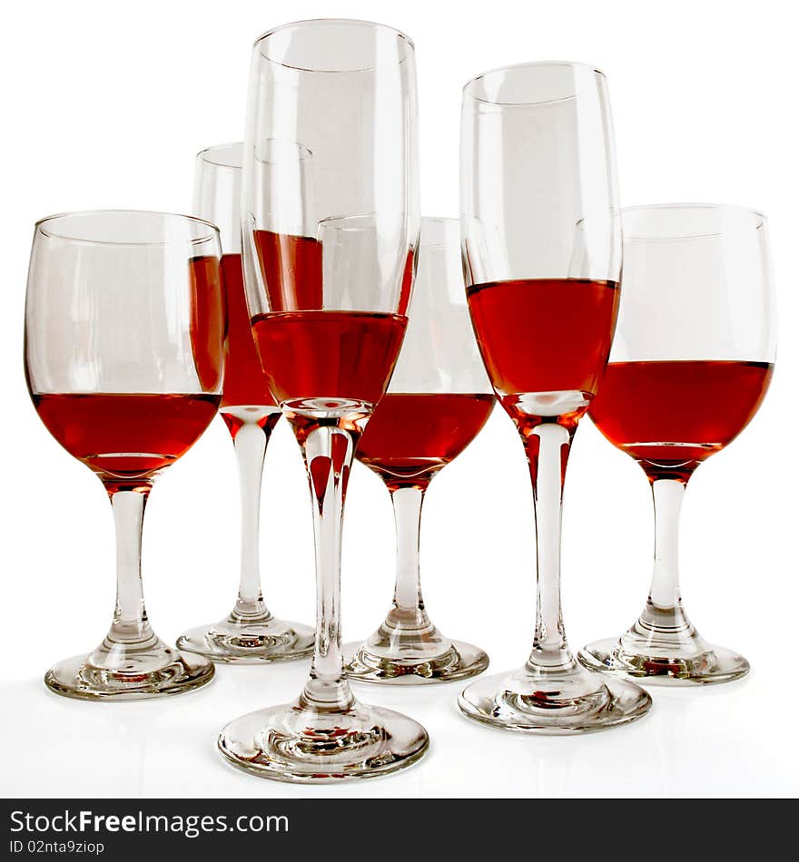 Six wine glasses of various sizes and various fills of red wine on white. Six wine glasses of various sizes and various fills of red wine on white