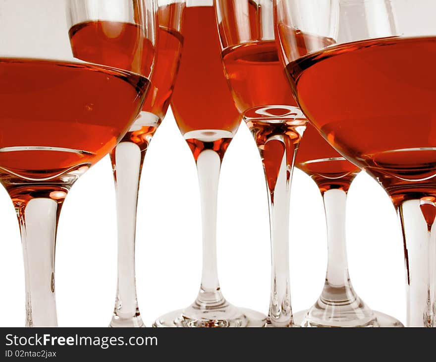 Wine glasses on a white background filled with various levels of a red wine. Wine glasses on a white background filled with various levels of a red wine