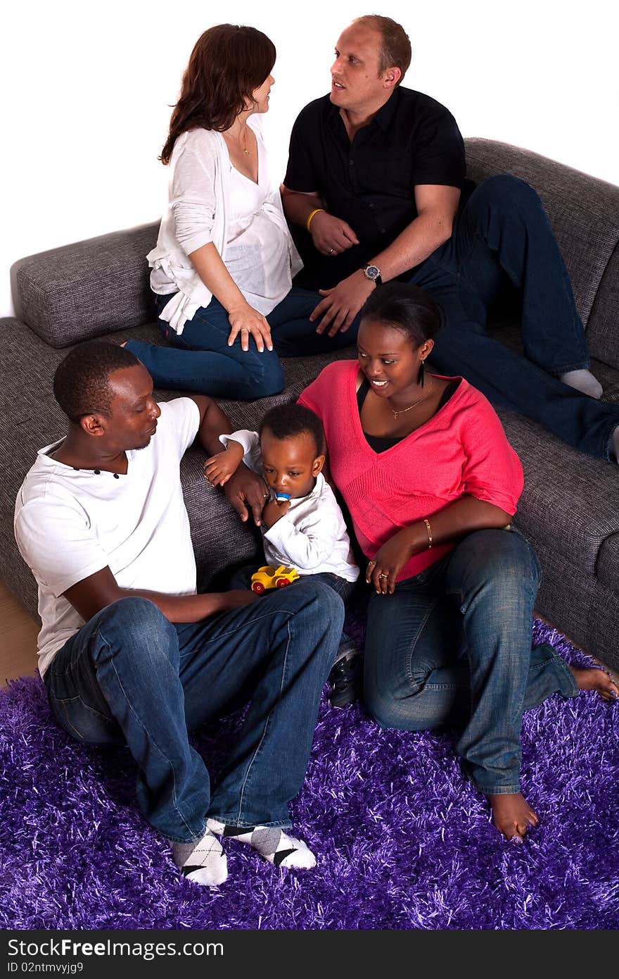 Young group of multiracial friends - two young families enjoying an afternoon at home. Young group of multiracial friends - two young families enjoying an afternoon at home.