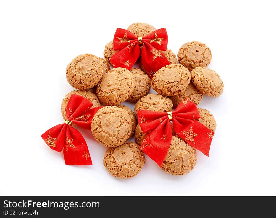 Almond cookies decorated with red velvet bows on white background. Almond cookies decorated with red velvet bows on white background