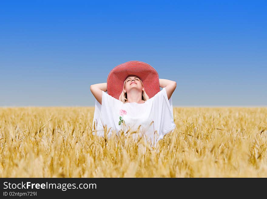 Beautiful woman with hat in wheat meadow on sunny day