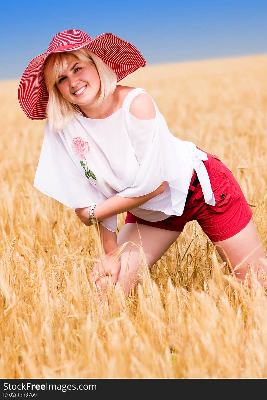 Beautiful woman with hat in wheat meadow on sunny day