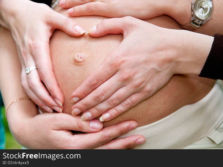 Heart shape made from hands on pregnant woman stomach. Heart shape made from hands on pregnant woman stomach