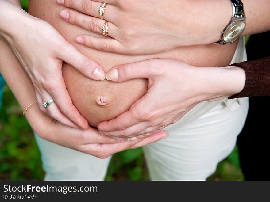 Heart shape made from hands on pregnant woman stomach