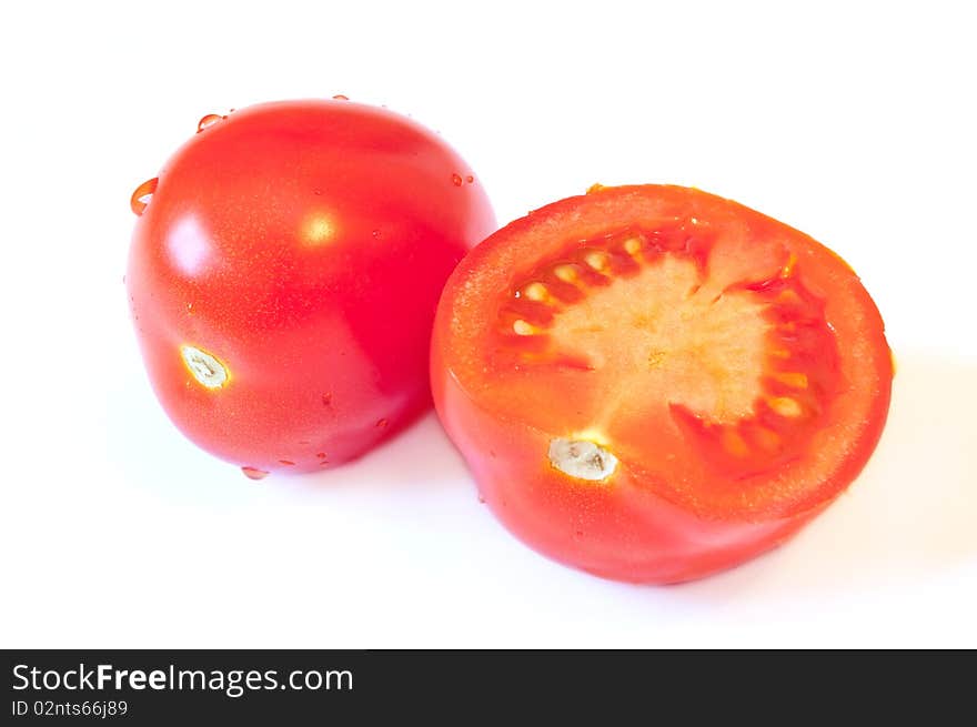 One and a half red tomato with a shadow on a white background