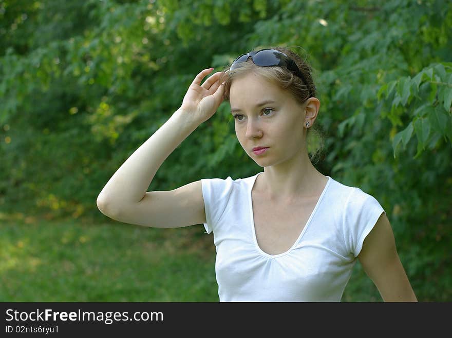 Girl in a white t-shirt holding sunglasses. Girl in a white t-shirt holding sunglasses