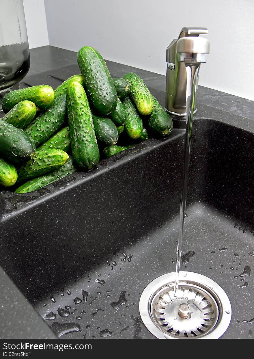 Closeup of sink with washed cucumbers ready to bottling and pickling at home. Closeup of sink with washed cucumbers ready to bottling and pickling at home.