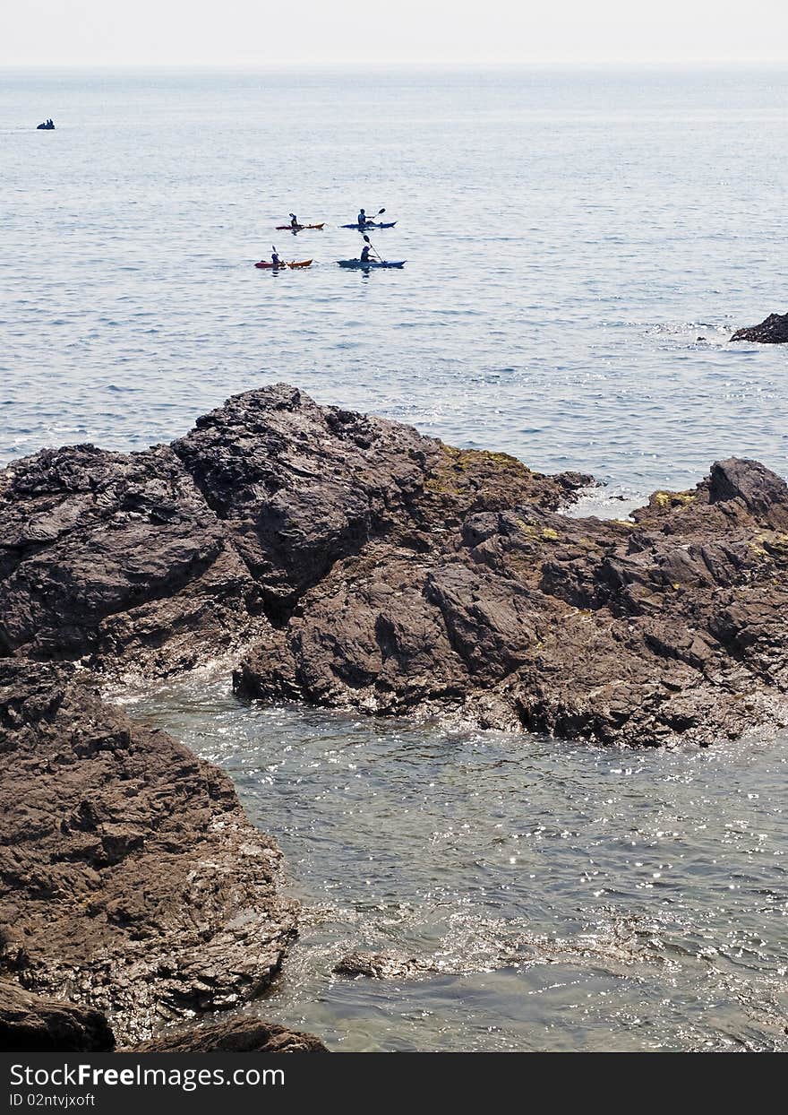 Anglesey coast canoeists in kayaks North Wales. Anglesey coast canoeists in kayaks North Wales