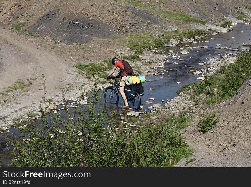 Mountain Biker Crossing River