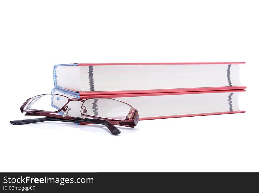 Two books and eyeglasses against white background