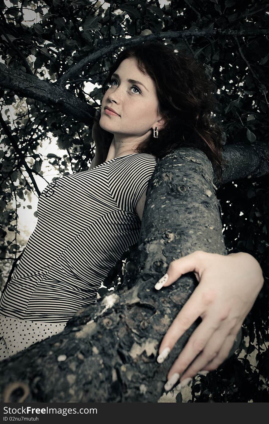 Young redhead woman holding an apple tree branch. Young redhead woman holding an apple tree branch