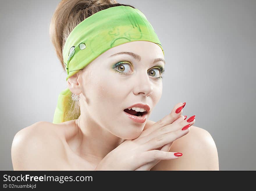 Closeup portrait of surprised woman with beautiful green eyes and green bandage on head